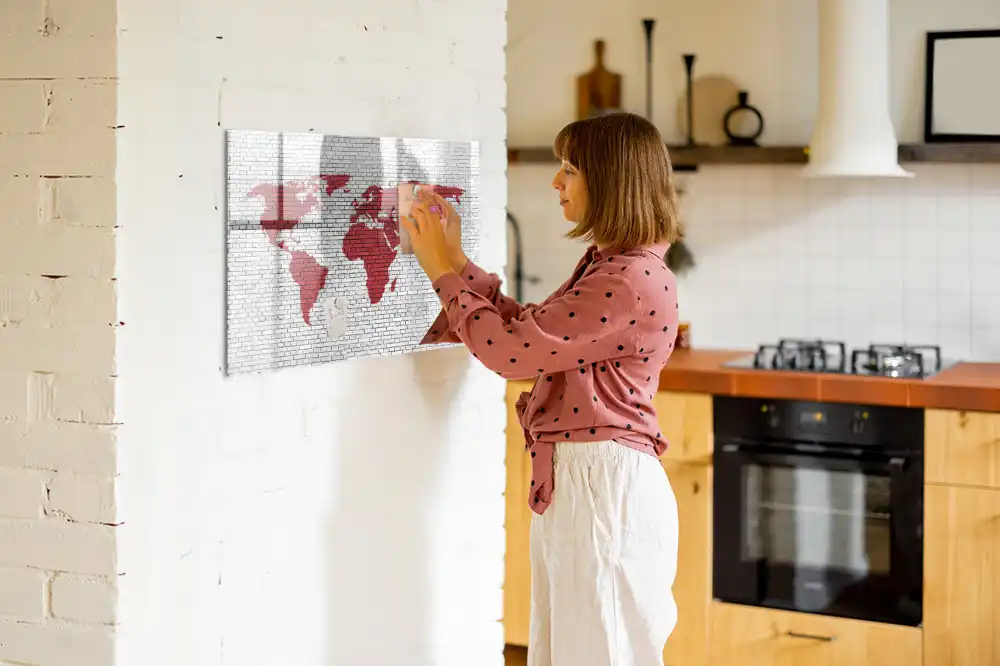 Tablă cu marker cu design de contur al continentelor pe fundal de cărămidă