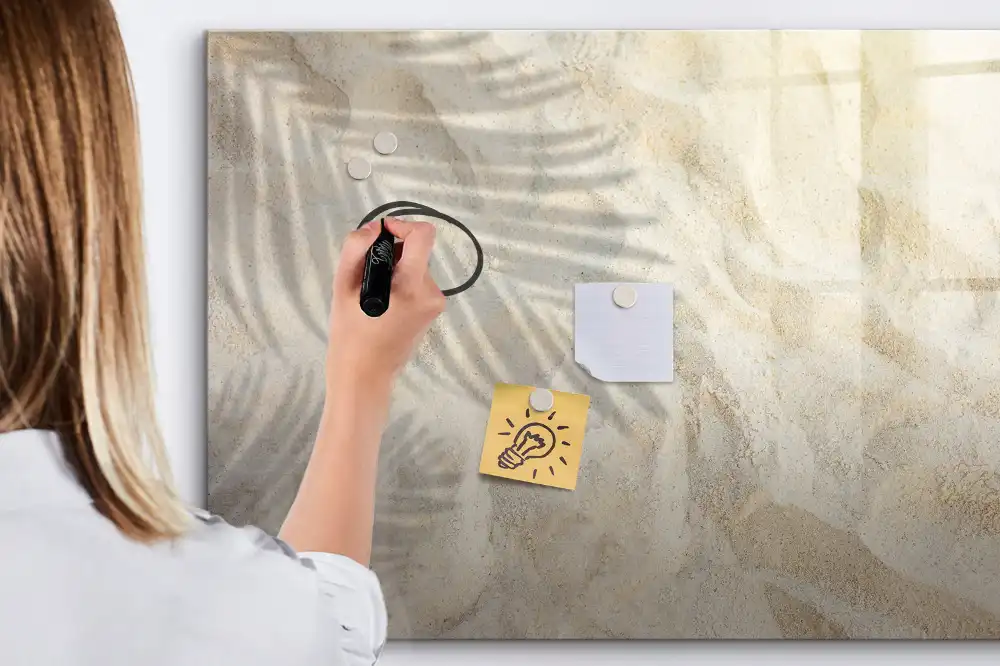 Tablă cu marker imprimată cu umbra unei frunze de palmier pe nisip